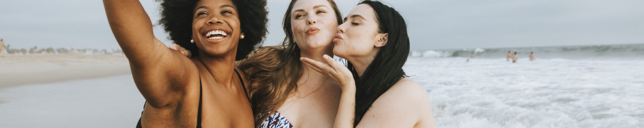 Beautiful curvy women taking a selfie at the beach